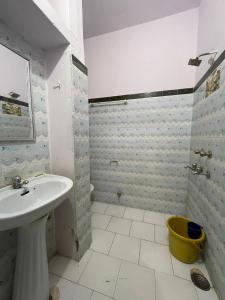 a white bathroom with a sink and a shower at Nomadic Backpackers Hostel in Jaisalmer