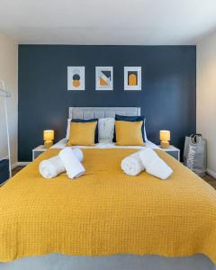 a bedroom with a large yellow bed with yellow pillows at Lovely Two Bed at Tanglewood in Hillingdon