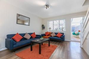 a living room with a blue couch and a table at Lovely Two Bed at Tanglewood in Hillingdon