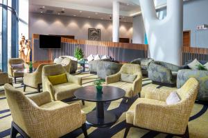 a lobby with chairs and a table and a tv at Hilton Garden Inn Mbabane in Mbabane