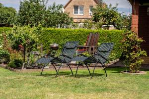 two lawn chairs and a grill in a yard at Ferienwohnung mit Gartenblick in Rechlin