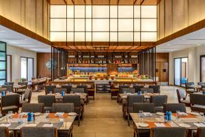 a dining room with tables and chairs and a library at Fairfield by Marriott Goa Benaulim in Benaulim