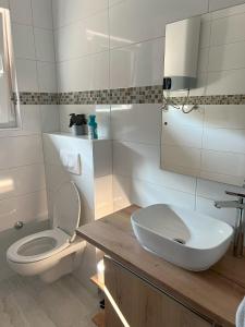 biała łazienka z toaletą i umywalką w obiekcie Villa Anchor w mieście Zadar