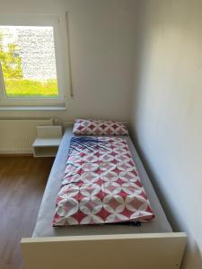 a bed sitting in a room with a window at F&M Wohnungen in Olpe in Wenden
