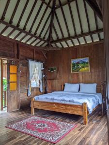 a bedroom with a bed in a wooden room at Le Desa Resort Syariah in Wonosobo