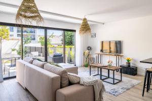 a living room with a couch and a table at Nouveau - Maison à 15min du centre ville Nantes in Orvault