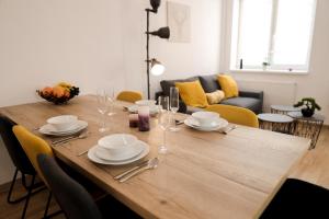a dining room table with plates and glasses on it at Apartmán 11 - Rezidence K Lanovce in Jáchymov