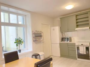 a kitchen with a table and a refrigerator and a window at Ålesund City Center - Modern 80-m2 flat with 3 bedrooms in Ålesund