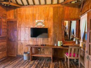 um quarto com uma parede de madeira, uma secretária e um espelho. em Le Desa Resort Syariah em Wonosobo