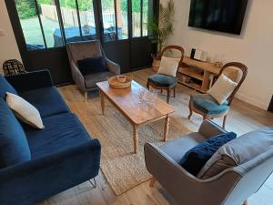 een woonkamer met blauwe banken en een tafel en stoelen bij La Longère Bordeaux gite de charme prés de Bordeaux in Cénac