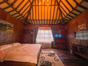 una camera con letto, TV e finestra di Le Desa Resort Syariah a Wonosobo