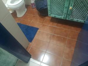 bagno con servizi igienici e pavimento piastrellato. di Apartamento 1 quarto Mongaguá a Mongaguá