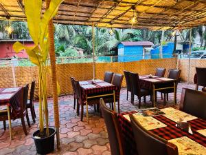 a restaurant with tables and chairs and a palm tree at Kepler Stay By AT Hotel Collection in Majorda