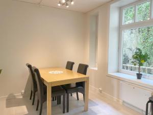 a dining room with a wooden table and chairs at Ålesund City Center - Modern 80-m2 flat with 3 bedrooms in Ålesund