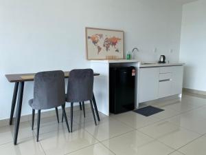 a kitchen with a table and two chairs and a refrigerator at Trefoil @ Studio Comfy~Dhomestay 2 in Shah Alam