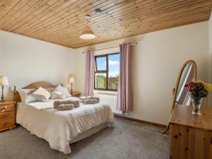 Un dormitorio con una cama grande y una ventana en Little Tara, Ballyconneely, en Ballyconneely