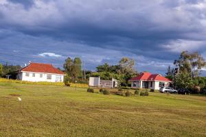 un campo con dos casas y un coche en un patio en Villa (2) Del Sol: Lakefront and Cruise Boat en Kisumu