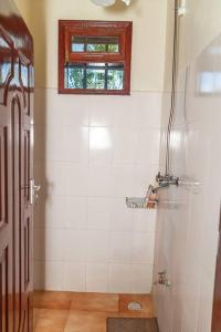 baño con ducha y ventana en Villa (2) Del Sol: Lakefront and Cruise Boat en Kisumu