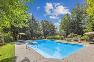 einen Pool im Garten mit Stühlen und Sonnenschirmen in der Unterkunft Castlerock in Stowe