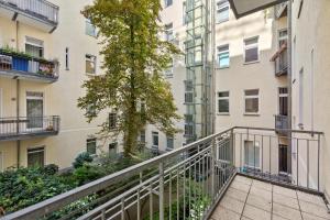 an apartment balcony with a tree in front of a building at Arbio I 1A Rooms & Apartments Prenzlauerberg Berlin in Berlin