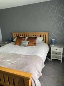 a bedroom with a large bed with two night stands at 'Kodi's Place' Well appointed 1 bedroom apartment with excellent transport links and free Wi-Fi in Whiteabbey