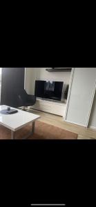 a living room with a tv and a white coffee table at Oslo Center 5 in Oslo