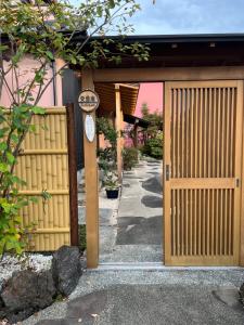 um portão de madeira para uma casa com uma cerca em Eishinan 栄進庵 em Fuji