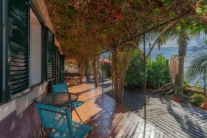 a balcony with a table and chairs and a view of the ocean at Cozy Villa Flora by Holiday Rental Madeira in Estreito da Calheta