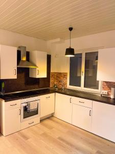 a kitchen with white cabinets and a sink at Historisches Haus am Fuße der Festung Ehrenbreitstein am schönen Rhein in Koblenz +16 photos