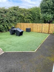 a backyard with two ping pong tables and a fence at 'Kodi's Place' Well appointed 1 bedroom apartment with excellent transport links and free Wi-Fi in Whiteabbey