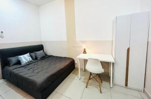 a small bedroom with a bed and a desk at Damen's 2BR Cozy Corner Near Sunway in Subang Jaya