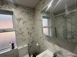 a bathroom with a sink and a large mirror at Modern 2 bedroom flat, SE6 in Catford