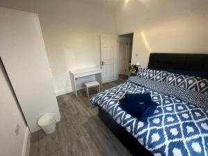 a bedroom with a bed with a blue pillow on it at Modern 2 bedroom flat, SE6 in Catford