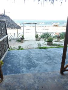 a view of the beach from the porch of a resort at Kibwana Village Bungalows in Matemwe