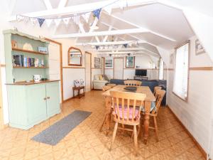 Una cocina y un comedor con mesa y sillas. en Suzanne's Beach Hut, en Norwich