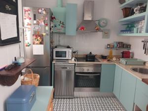 a small kitchen with a stove and a microwave at Habitación privada con baño. in Cádiz
