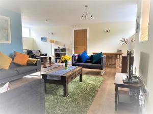 a living room with two couches and a table at The Secret Well in Shaldon