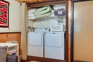 a white refrigerator in a room with a shelf at Decks, Grills and Fire Pit Camp Connell Hideaway! in Camp Connell