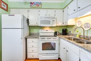 a kitchen with white appliances and a white refrigerator at Coastal Murrells Inlet Condo with Balcony! in Myrtle Beach