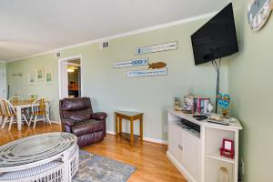 a living room with a flat screen tv on the wall at Coastal Murrells Inlet Condo with Balcony! in Myrtle Beach