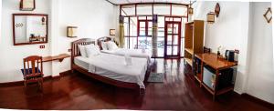 1 dormitorio con 2 camas, mesa y espejo en Dokchampa Guesthouse en Ban Khon