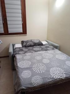 a small bedroom with a bed and a window at La pecorella in vacanza IUN R3384 in Pula