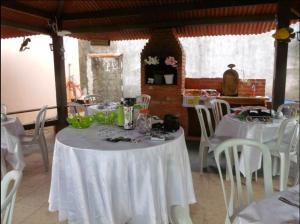 安格拉杜斯雷斯的住宿－Pousada Flor de Liz，用餐室配有白色的桌子和白色的椅子
