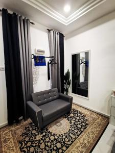 a living room with a chair and a mirror at MINI HOTEL CONCEPT in Kuala Terengganu