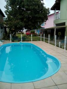 a large blue swimming pool in a courtyard at Pousada Flor de Liz in Angra dos Reis