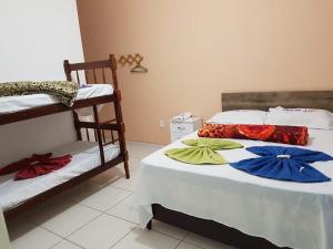 two beds with umbrellas on them in a room at Pousada Flor de Liz in Angra dos Reis