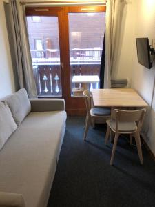 a living room with a couch and a table and a window at Studio Tignes Val Claret in Tignes