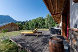 a wooden deck with a chair on a house at Chalet le Chardon Bleu in Villarembert
