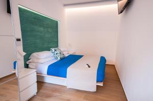 - une petite chambre avec un lit et un tableau noir vert dans l'établissement White Home, à Castellammare del Golfo