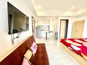 a living room with a couch and a kitchen at Prince Mall Appartment - 400m to Sokha Beach in Sihanoukville